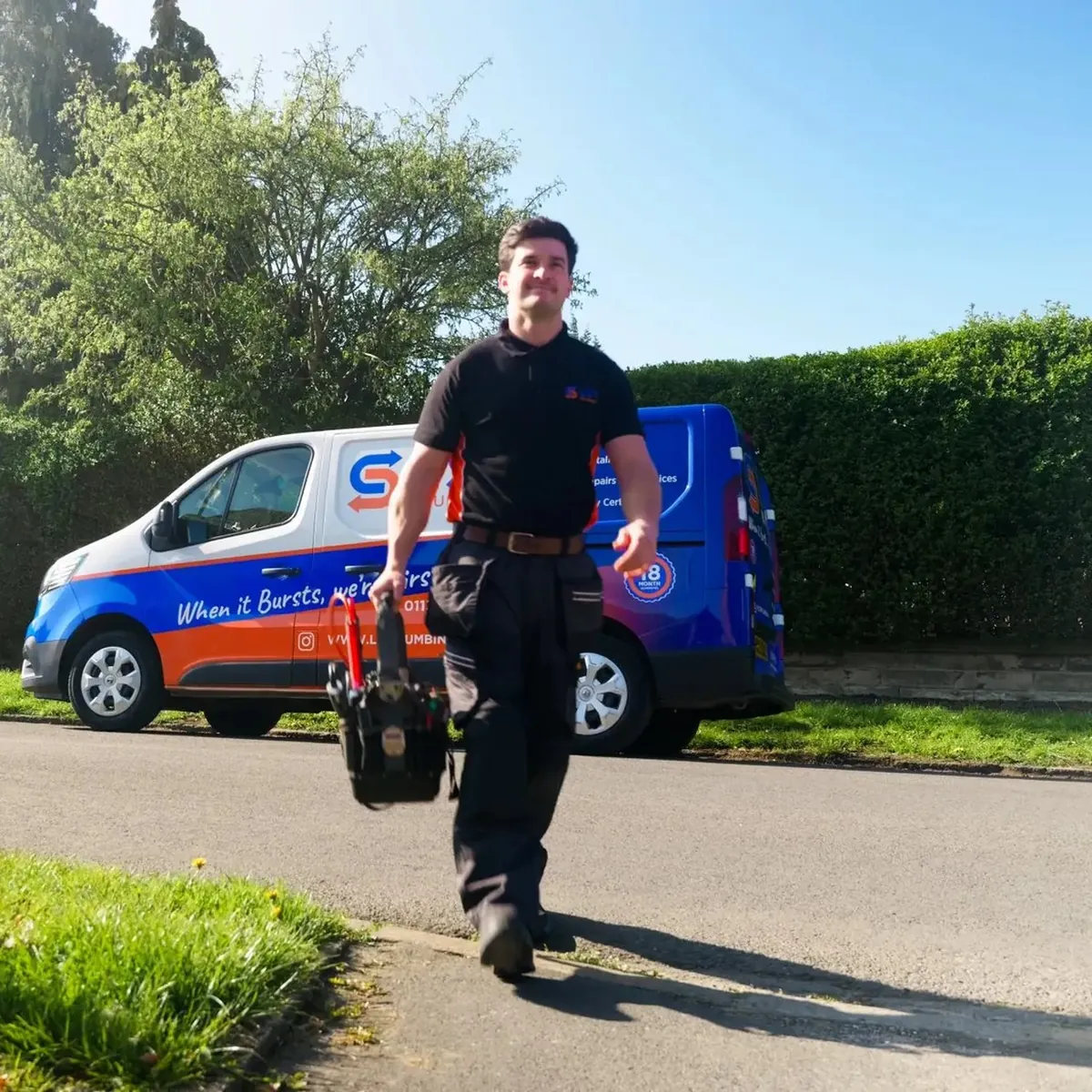 An LS1 Plumbing engineer walking from the blue and orange company van with his tool bag
